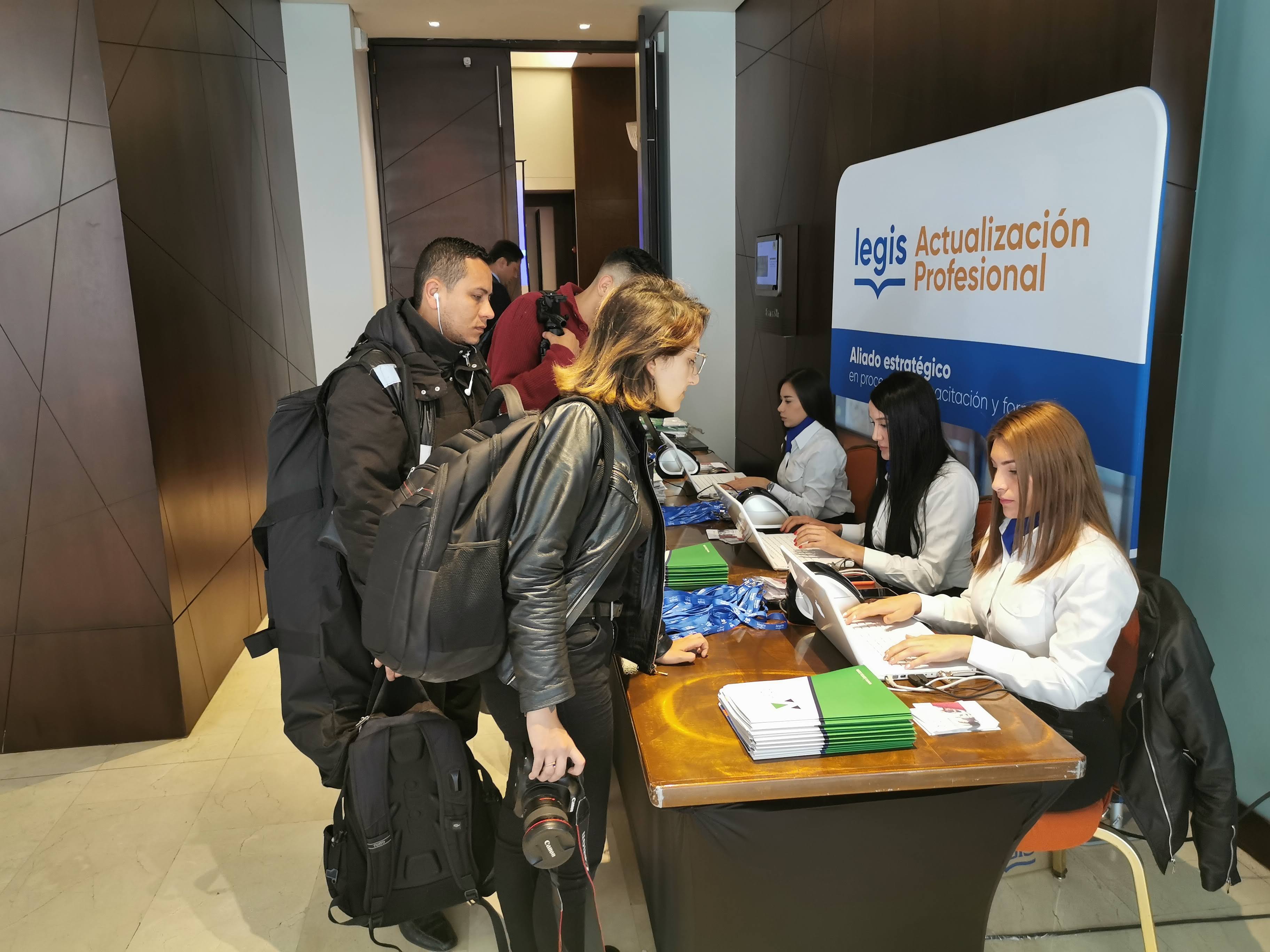 Equipo de acreditación atendiendo asistentes